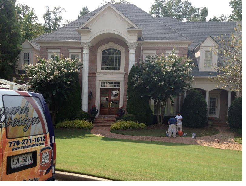 Trademark Design crew and company van at a large brick home in Metro Atlanta