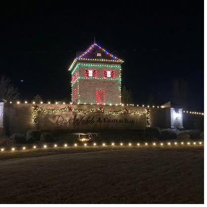 Community monument sign wrapped in holiday lighting